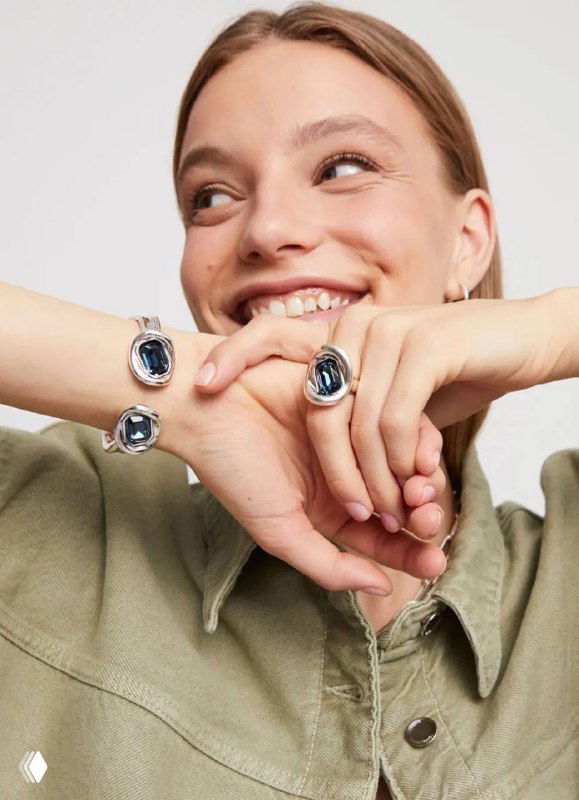 Модель с двумя кольцами и браслетом UNOde50 демонстрирует украшения серии Ser Valiente в синем и серебристом тонах на светлом фоне.