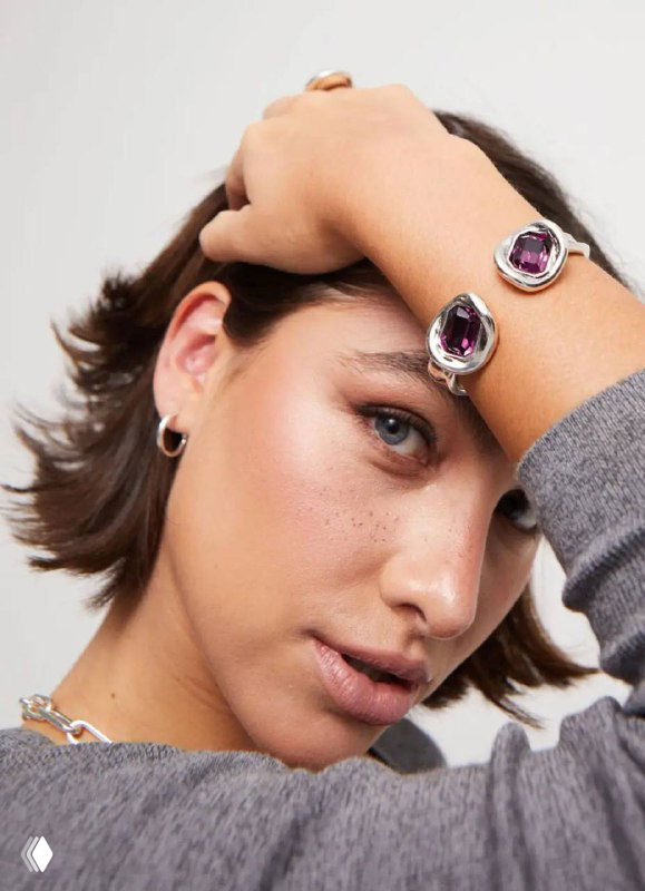Портретная съемка модели в браслетах и кольцах UNOde50, акцент на крупные разноцветные кристаллы и естественный повседневный образ.