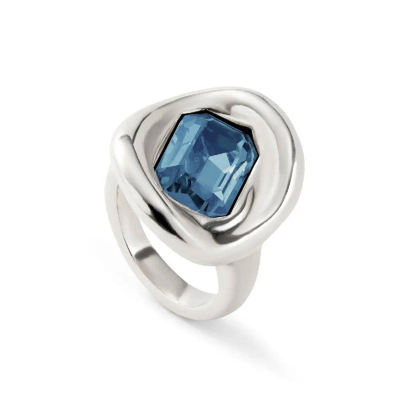 Крупный план серебряного кольца UNOde50 с глубоким синим кристаллом на белом фоне, подчёркнута форма, огранка и металлическая оправa.