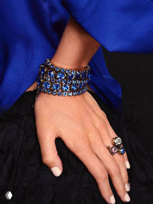 Крупный план запястья в синем наряде: широкий браслет CONIAN с синими кристаллами Swarovski и украшения на пальцах, стильный образ