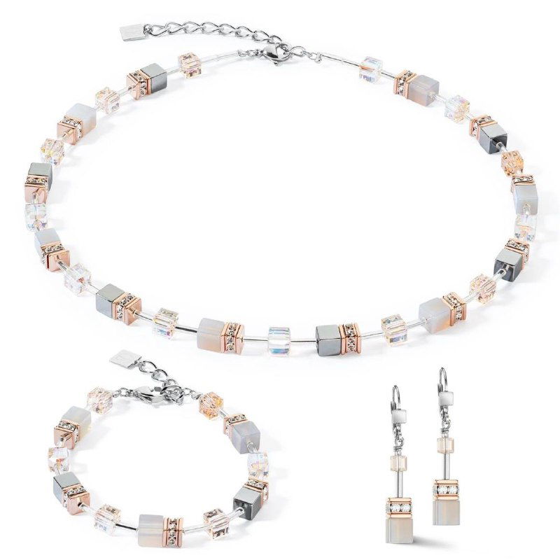 Комплект Coeur de Lion: ожерелье, браслет и серьги с кубическими керамическими и металлическими элементами в светлых пастельных оттенках.