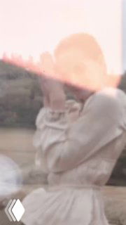 Размытый художественный кадр с моделью в светлом платье на фоне пейзажа; акцент на атмосферу осенней прогулки и лёгкие украшения на образе.