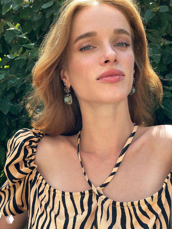 Портретная фотография женщины-модели на фоне зелёной листвы, демонстрирующая серьги Fiore di Firenze с мятными камнями и филигранной отделкой