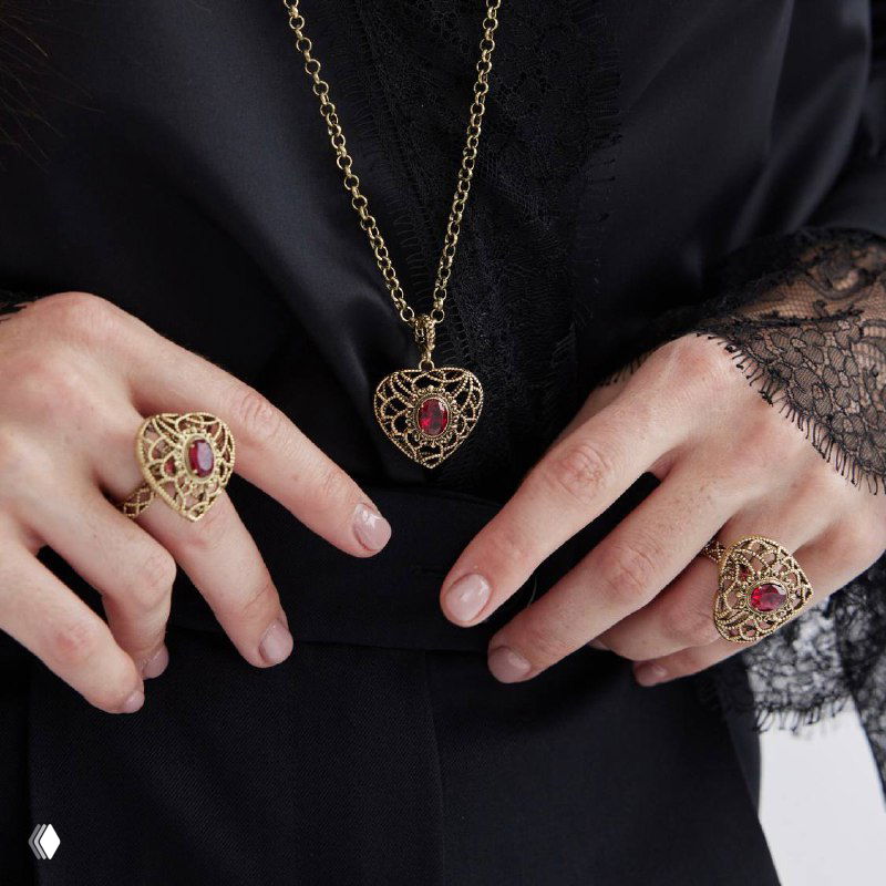 Модель демонстрирует комплект: подвеска, кольца и серьги AMORE ETERNO на тёмной одежде, акцент на винтажный ажур и красные вставки.