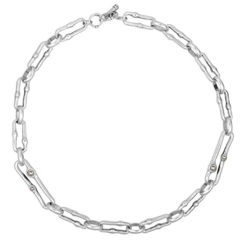 Крупная студийная съёмка серебристого плоского колье-цепи в форме удлинённых звеньев на белом фоне — товарный ракурс