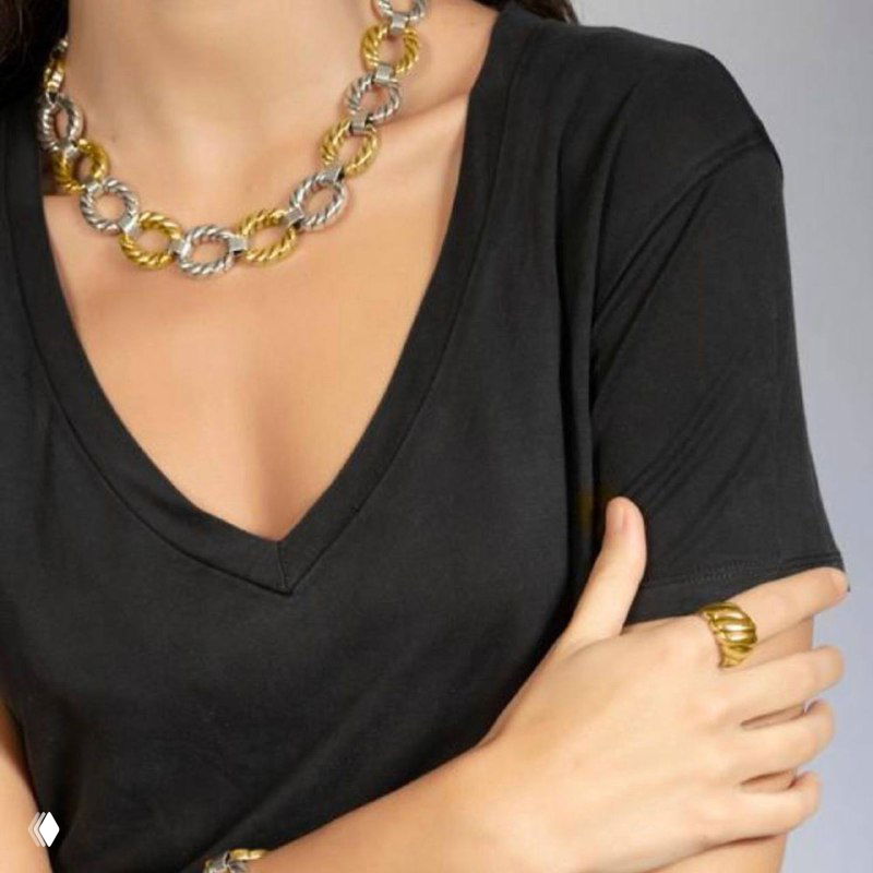 Женская модель в чёрной футболке демонстрирует колье с круглыми звеньями и соответствующее кольцо на пальце — стилизованный образ