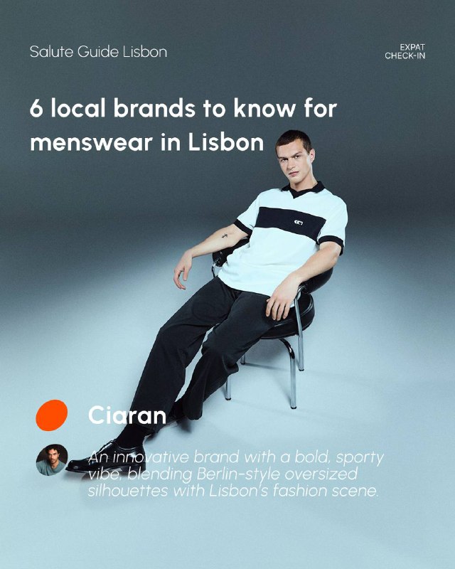Seated male model in a casual polo and dark trousers against a muted studio background, illustrating relaxed sporty-casual menswear and styling details.