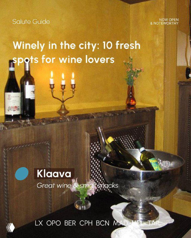 Wine bottles chilled in a metal bucket on a marble surface with warm decorative lighting, an intimate corner of a wine-focused venue.