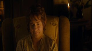 Тёплый интерьер: взрослый мужчина в кресле улыбается при свечах и мягком освещении, создавая атмосферу спокойной беседы и уюта.