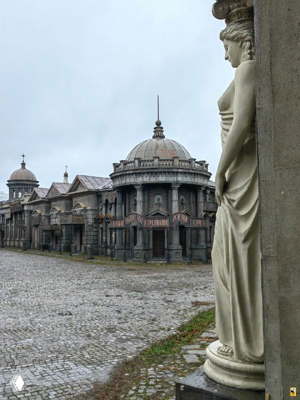 Ряды зданий в одном ракурсе и статуя на переднем плане — композиция сцены, где видна акустика эпохи и приёмы декорации Мосфильма.