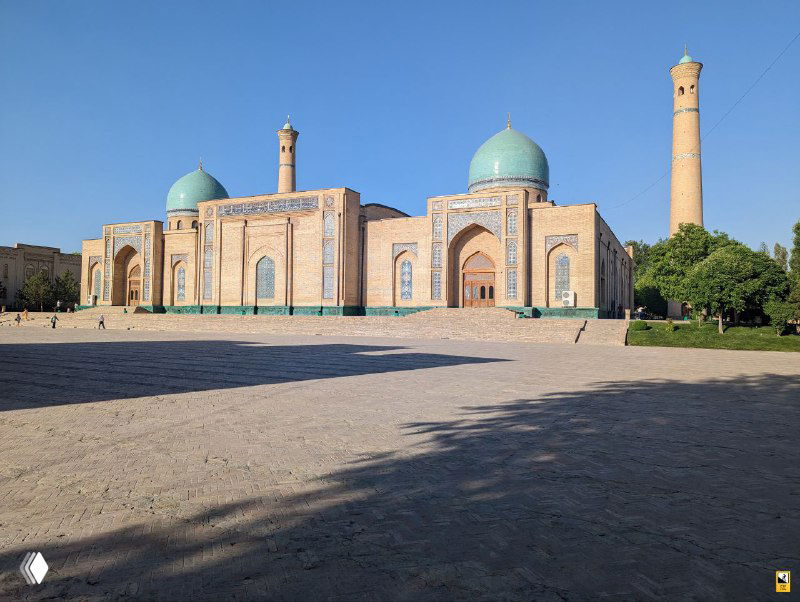 Ансамбль Хазрати Имам в Ташкенте с бирюзовыми куполами и минаретом на фоне голубого неба; просторная площадь и игра света создают спокойную атмосферу.
