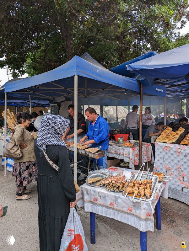 Уличные торговые палатки на рынке Чорсу: продавцы, яркие продукты и посетители под синими тентами; живое торговое пространство и запахи еды ощущаются даже на фото.