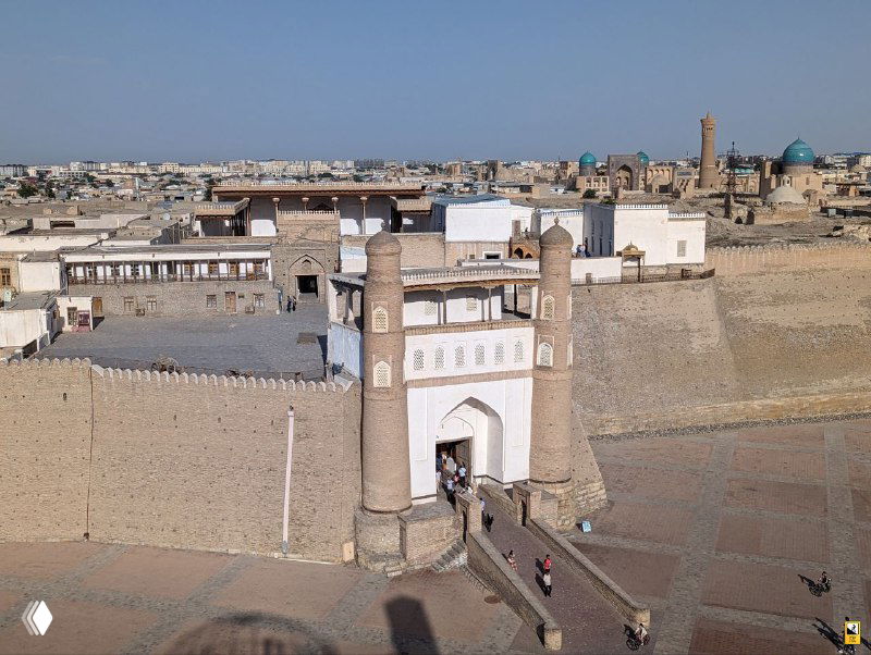 Вид с смотровой площадки на крепость Арк в Бухаре: ворота, глинобитные стены, вход и окружающая историческая застройка.