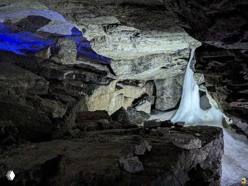 Интерьер Кунгурской ледяной пещеры: просторный каменный зал, своды и скопления льда, подсветка создаёт атмосферу тайны; фото из экскурсии в Пермском крае.