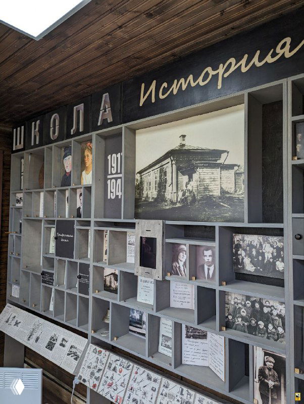 Музейная витрина с фотографиями и экспонатами истории школы в Мелихове: стенды, архивные снимки и предметы, собранные в тематической экспозиции.