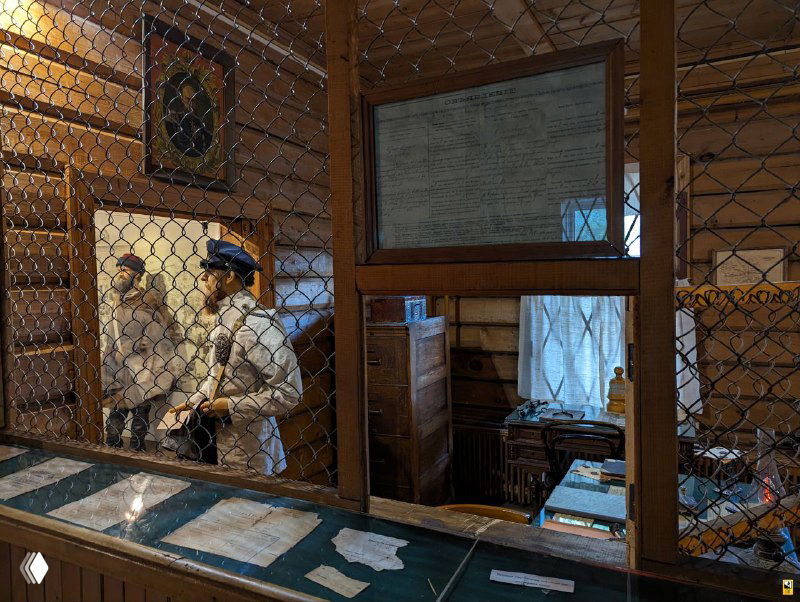 Интерьер почтового отделения в музее: деревянная приёмная стойка, ретро-атрибутика и сценографический манекен в форме, передающие атмосферу начала XX века.