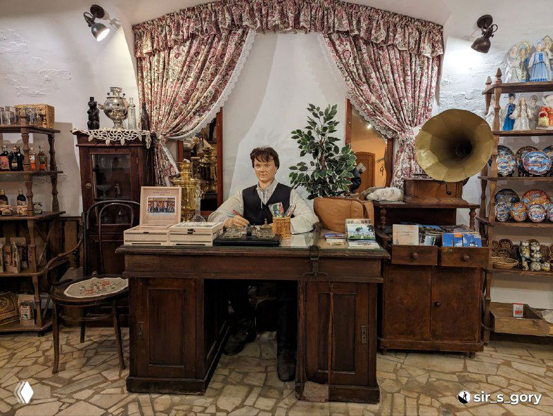 Интерьер сувенирной лавки в Костроме: прилавок с кассой, граммофон и деревянная мебель в ретро‑стиле, атмосферная витрина.