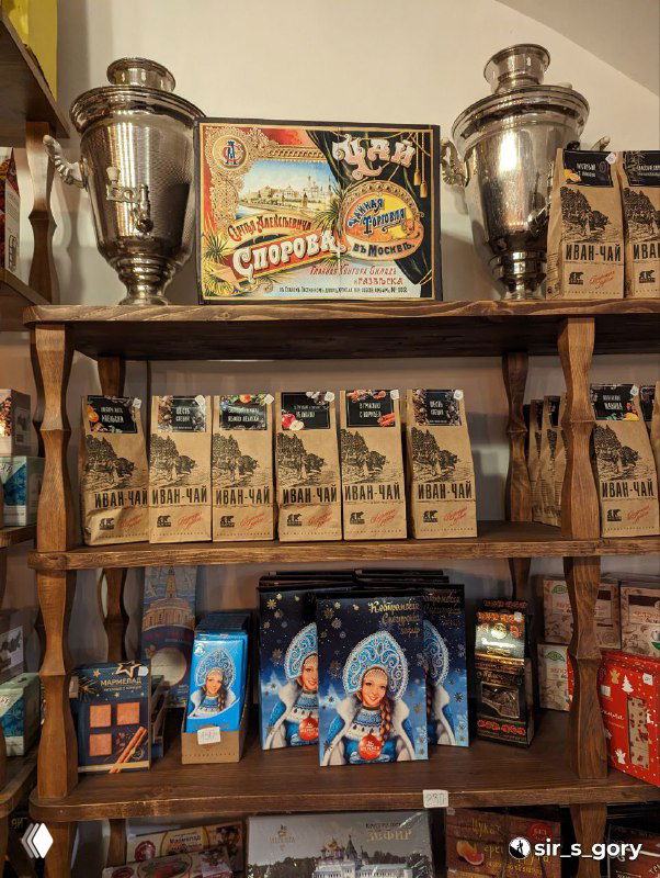 Полки с упаковками местных сладостей и самоварами в магазине: местная кондитерская продукция и традиционная подача сувениров.