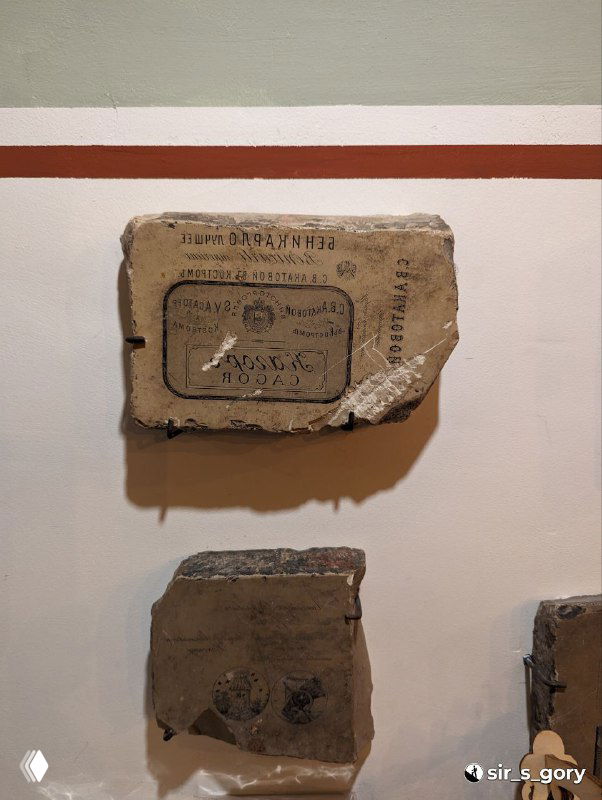 Фрагменты старых упаковок и маркировки на стенде в музее‑магазине, демонстрация истории упаковки и товарного наследия региона.