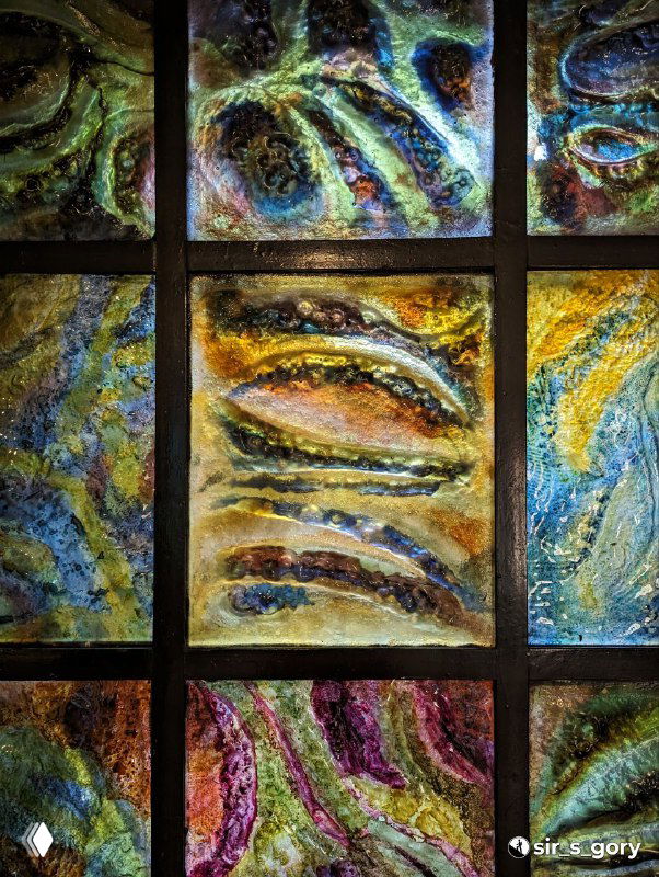 Радужные витражи или декоративные панели с янтарными мотивами и мозаичным рисунком в экспозиции музея.