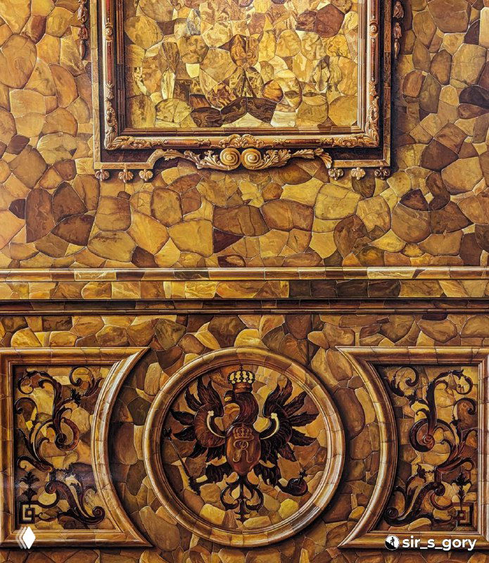 Фрагменты восстановленной Янтарной комнаты: орнамент и панно из полированных пластин янтаря в музейной раме.