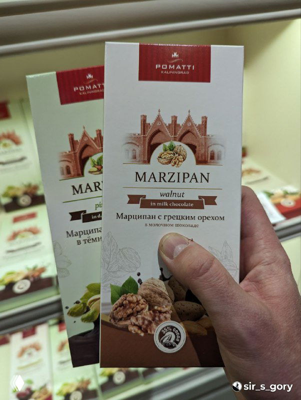 Упаковки марципана в руках автора: шоколадно-ореховая упаковка марки Romatti, видно название и оформление продукта в магазине сувениров.