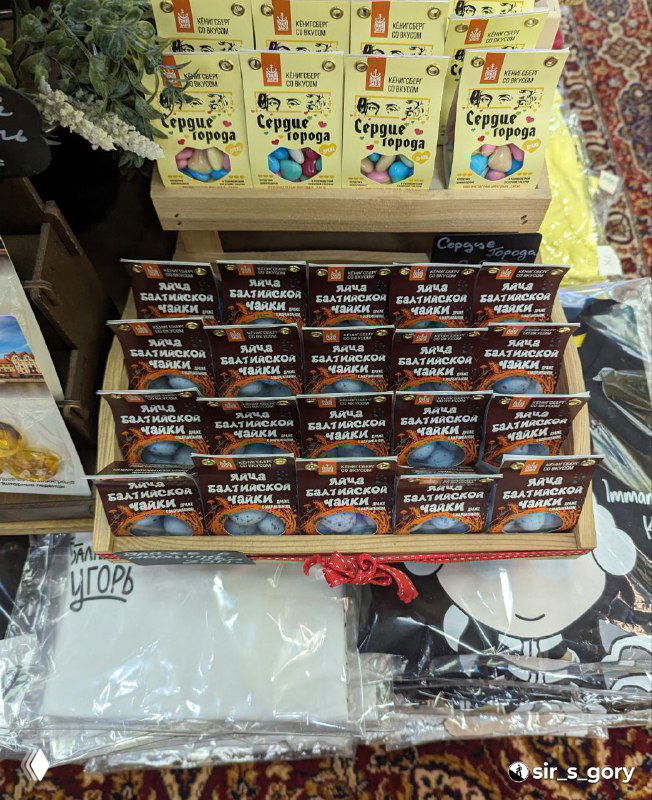 Стойка с коробками марципановых сладостей и сувениров: многообразие вкусовых вариантов и яркие этикетки в магазине.