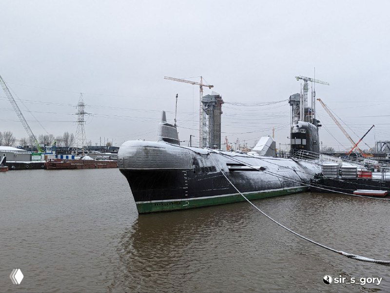 Дизель-электрическая подводная лодка Б‑413 пришвартована у причала Музея Мирового океана в Калининграде; общий вид с набережной и музейными судами на фоне.