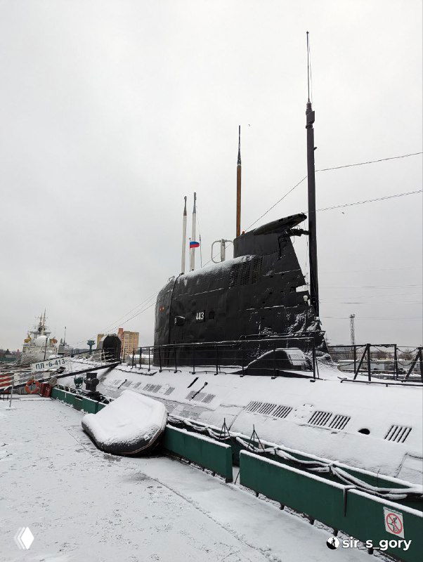Надстройка и рубка подводной лодки Б‑413, покрытая снегом; вид на антенны, флаг и элементы палубы на зимнем фоне музейного причала.