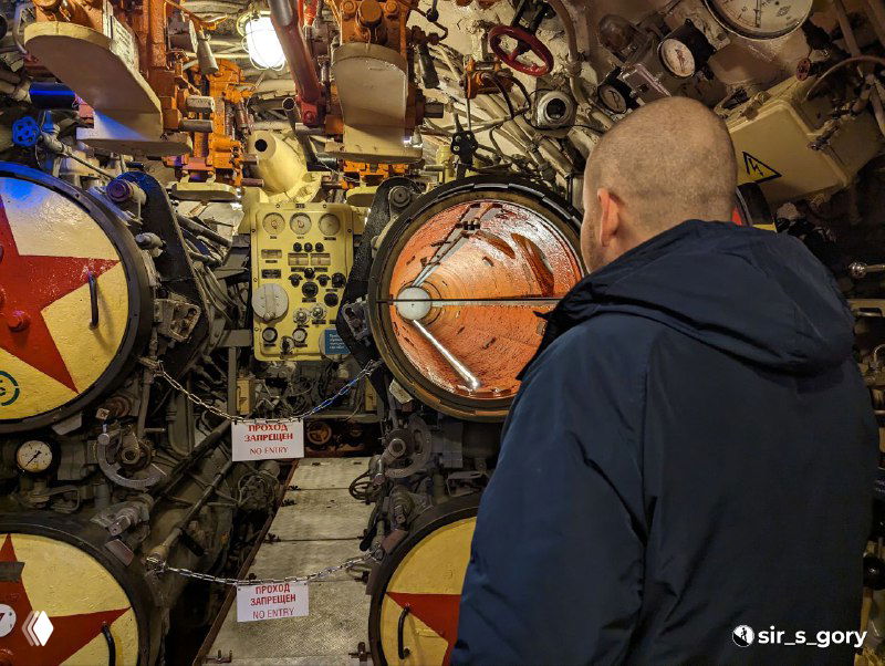 Внутренний вид боевого отделения подводной лодки: плотная компоновка приборов, люки и панели, множество датчиков и механизмов внутри корпуса.