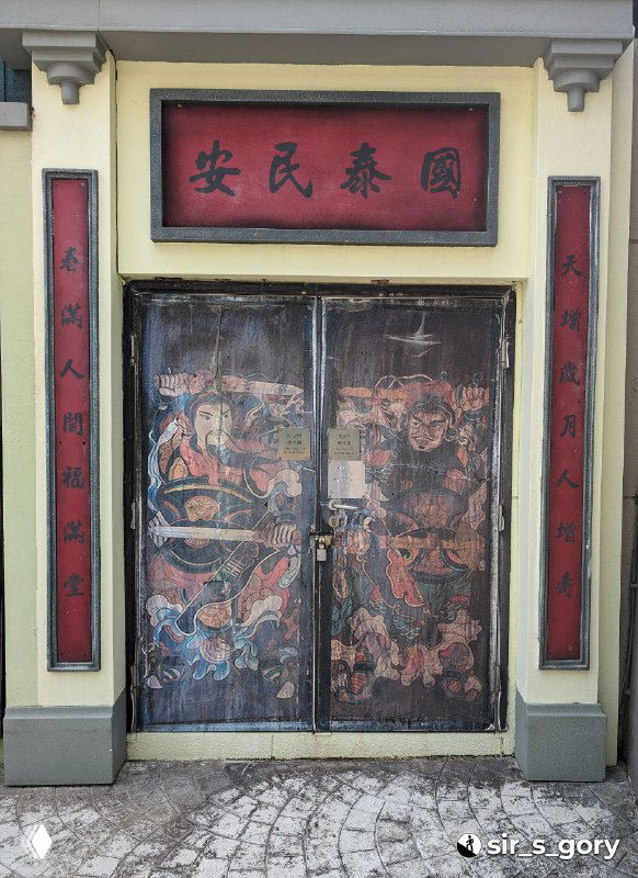 Деревянные двери с изношенной настенной росписью и персонажами в традиционном стиле, видна старая краска и потертости.