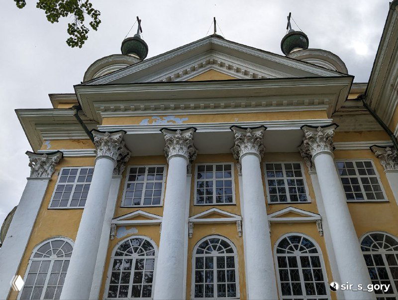 Крупный план колонн и окон барочной церковной архитектуры в Тотьме, видны коринфские капители и декоративные детали фасада.