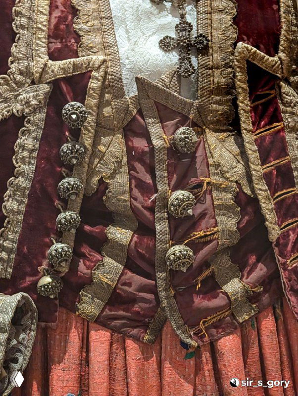 Фрагмент национального мужского костюма с пуговицами, тканевыми вставками и сложной вышивкой — экспонат, демонстрирующий региональные отличия.