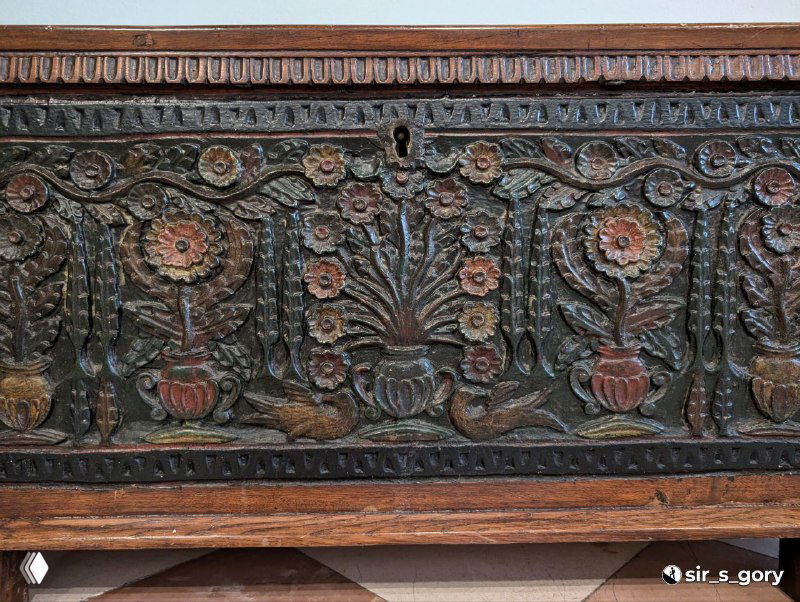 Деревянная панель или сундук с резным цветочным орнаментом, фрагмент народного интерьера из музейной экспозиции Черногории.