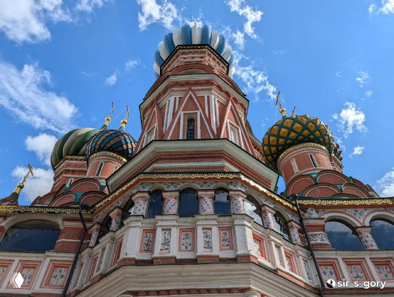 Фрагмент фасада и куполов Покровского собора крупным планом: архитектурные орнаменты, краски и перспектива съёмки снизу.