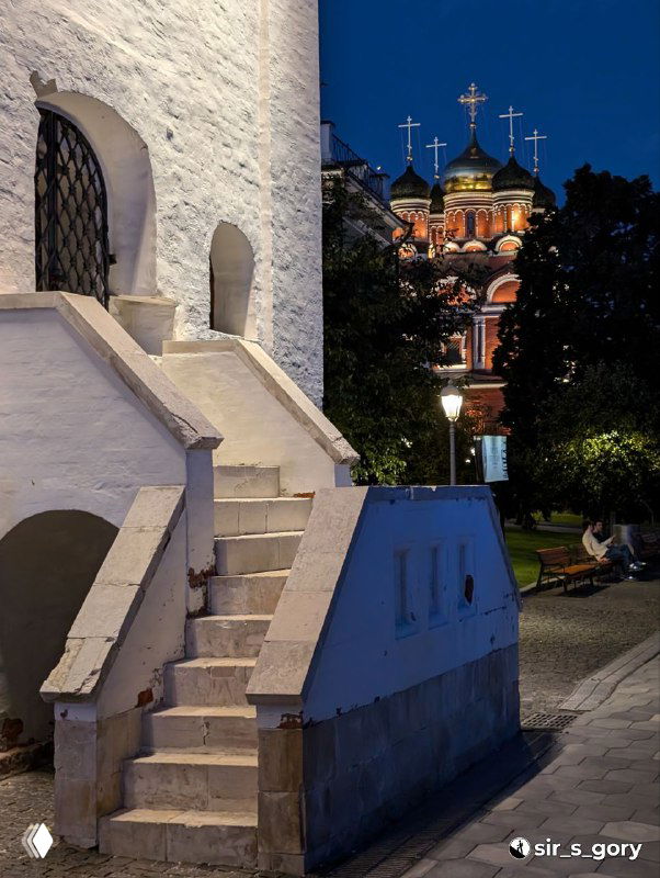 Вечерний кадр в Зарядье: архитектурные детали и купола церкви в тёплом вечернем освещении рядом с тихими аллеями парка