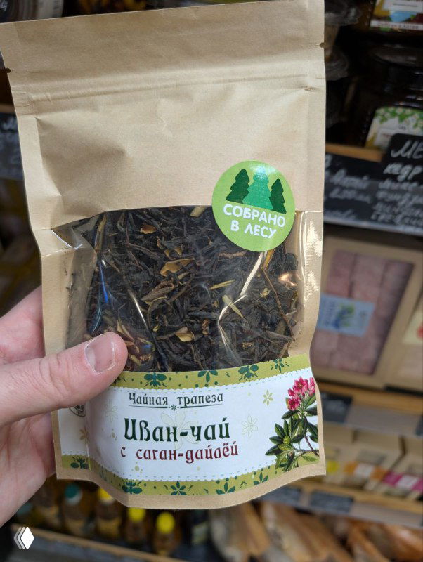 Пакет фермерского иван-чая в крафтовой упаковке на полке лавки, крупный план этикетки с надписью «Иван-чай» и стикером «Собрано в лесу».