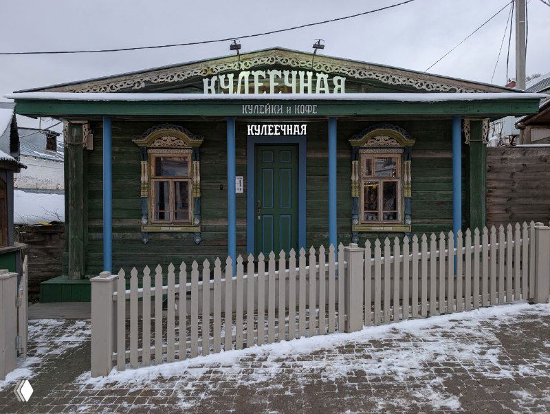 Зелёный деревянный дом-музей в Плёсе с декоративными наличниками и забором, снежный наст и традиционная русская архитектура.