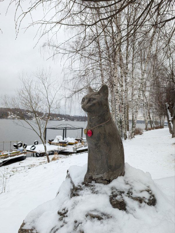 Скульптура кошки на снежном постаменте у набережной — местная городская деталь в условиях холодного времени года.