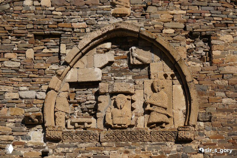 Каменная барельефная резьба над входом храма Тхаба-Ерды: арка с фигурными мотивами и сохранившиеся скульптурные фрагменты на фасаде.