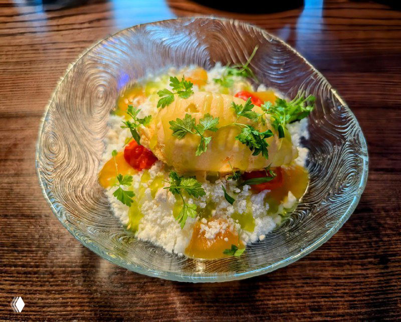 Прозрачная стеклянная миска с десертом: запаренная морковь, белый шоколад и тыквенное мороженое, украшенные листиками зелени — северная подача Roomi.