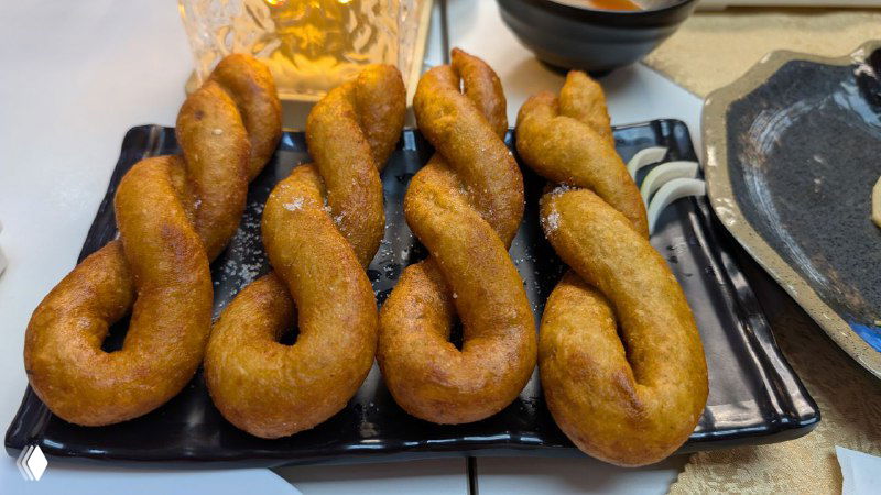 Сладкие заплетённые картофельные «косички» на решётке, золотистая корочка и хрустящая текстура — десертный вид блюда.