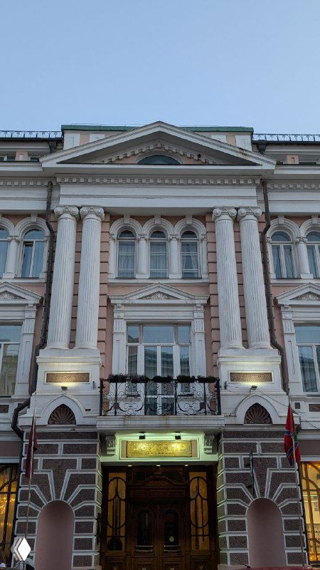 Фасад исторического здания во Владивостоке: классические колонны и богатая отделка в европейском стиле, снимок сделан крупным планом.
