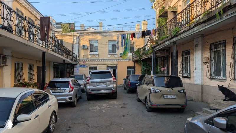 Двор с припаркованными автомобилями и бельём между домами — пример смешения жилых кварталов и азиатских подворотен во Владивостоке.
