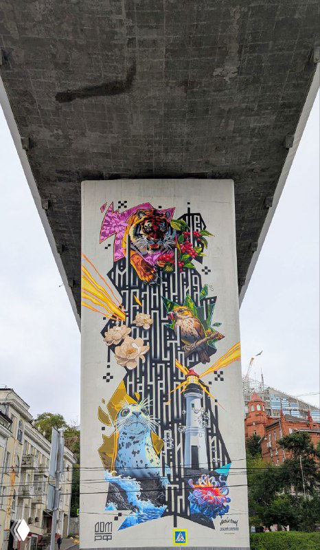 Граффити и настенная роспись под мостом, вид снизу на бетонную поверхность и колоритный уличный арт в городской среде Владивостока.