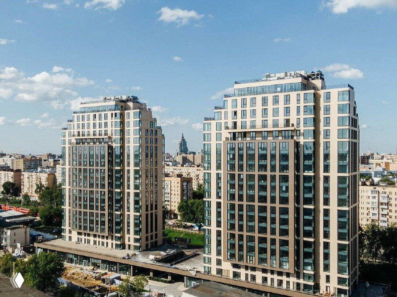 Дневной вид двух параллельных жилых корпусов в кирпично-бетонном стиле, окружённых улицами и зелёными зонами — визуализация квартала.