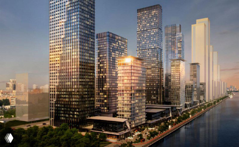 Рендер проектируемого комплекса: несколько высоких стеклянных башен вдоль набережной, вечернее освещение и пешеходная набережная.