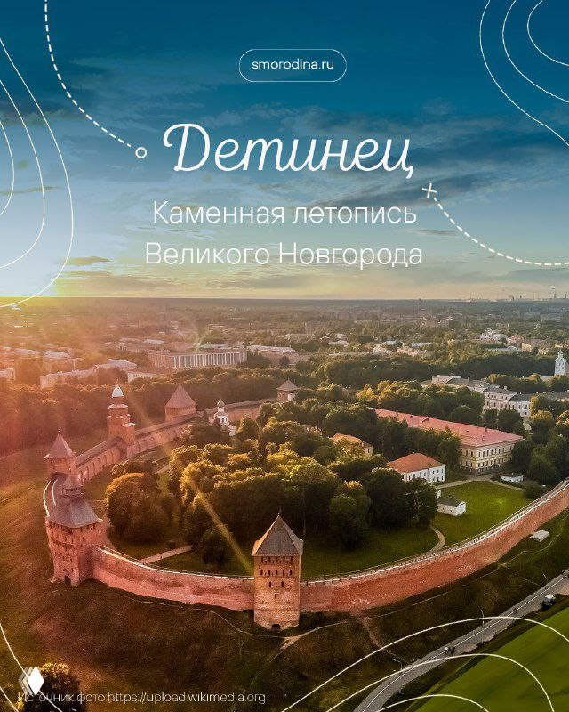 Аэрофотография Детинца Великого Новгорода: панорама кремля с кирпичными башнями, Софийским собором и рекой на горизонте в зелёной окружении.