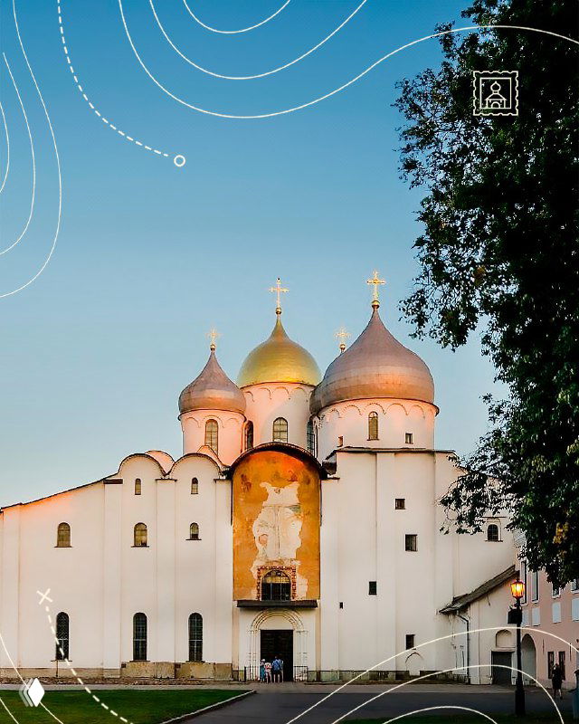 Фасад Софийского собора Великого Новгорода: белые стены, золочёные купола и фрески у входа на фоне мягкого дневного неба и зелёных деревьев.