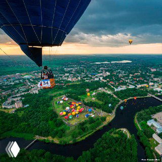 Кабина воздушного шара над городом Великие Луки: панорама реки, парков и площадки фестиваля — вид полёта над местом события.